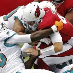 Arizona Cardinals quarterback Kevin Kolb, right, is sacked by the Miami Dolphins during the first half of an NFL football game, Sunday, Sept. 30, 2012, in Glendale, Ariz. (AP Photo/Matt York)
