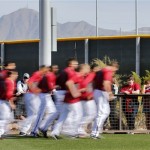 Fans watch as the Arizona Diamondbacks run during spring training baseball practice, Monday, Feb. 10, 2014, in Scottsdale, Ariz. (AP Photo/Matt York)