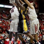 Southern Mississippi's Norville Carey (21) is defended by Arizona's Angelo Chol (30) and Brandon Ashley, right, during the first half of an NCAA college basketball game at McKale Center in Tucson, Ariz., Tuesday, Dec. 4, 2012. (AP Photo/Wily Low)