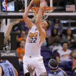  Phoenix Suns' Miles Plumlee (22) dunks as Memphis Grizzlies' Zach Randolph (50) defends during the first half of an NBA basketball game on Thursday, Jan. 2, 2014, in Phoenix. (AP Photo/Matt York)