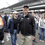 San Francisco 49ers head football coach Jim Harbaugh, who will drive the pace car to start the Indianapolis 500 auto race, walks through the pit area before the start of the race at the Indianapolis Motor Speedway in Indianapolis Sunday, May 26, 2013. (AP Photo/Michael Conroy)