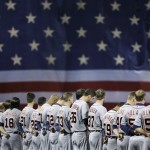 Detroit Tigers players stand in front of a giant American flag during the national anthem before Game 1 of the American League baseball championship series against the Boston Red Sox Saturday, Oct. 12, 2013, in Boston. (AP Photo/Matt Slocum)