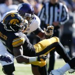 Iowa running back Damon Bullock (5) dives for extra yardage as he is hit by Northwestern defensive lineman Deonte Gibson (98) during the second half of an NCAA college football game Saturday, Oct. 26, 2013, at Kinnick Stadium in Iowa City, Iowa. (AP Photo/Brian Ray)
