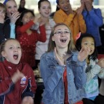 Brianna Anick, 10, Melissa Figliuolo, 14, and Sophie Yang, 10, cheer on Charlie White and Meryl Davis, as the duo competes in the Sochi 2014 Winter Olympics on Monday, Feb. 17, 2014, in Canton, Mich. On Monday, Charlie White and Meryl Davis, who train in suburban Detroit, became the first Americans to win an ice dance gold medal. (AP Photo/The Detroit News, Clarence Tabb)