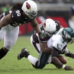 Philadelphia Eagles quarterback Michael Vick, right, has the ball knocked out of his hands as he is tackled by Arizona Cardinals linebacker Sam Acho, center, as Cardinals defensive tackle Darnell Dockett, left, looks on in the second quarter of an NFL football game on Sunday, Sept. 23, 2012, in Glendale, Ariz. (AP Photo/Paul Connors)
