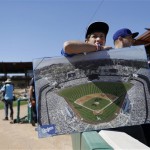  Los Angeles Dodgers fan Noah Perry, from Los Angeles, holds a giant picture of Dodger Stadium as he waits for autographs before an exhibition spring training baseball game against the San Francisco Giants on Tuesday, Feb. 26, 2013 in Glendale. Ariz. (AP Photo/Marcio Jose Sanchez)