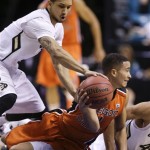 Colorado's Askia Booker, left, tries to strip the ball as Oregon State's Challe Barton looks to pass in the second half during a Pac-12 tournament NCAA college basketball game on Wednesday, March 13, 2013, in Las Vegas. Colorado won 74-68. (AP Photo/Julie Jacobson)