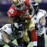 San Francisco 49ers tight end Vernon Davis (85) runs between Baltimore Ravens linebacker Courtney Upshaw, left, and Ray Lewis during the first half of the NFL Super Bowl XLVII football game, Sunday, Feb. 3, 2013, in New Orleans. (AP Photo/Patrick Semansky)
