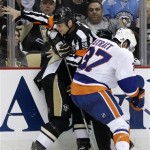 
Referee Chris Lee (28) gets pinned between Pittsburgh Penguins' Matt Cooke, rear, and New York Islanders' Brian Strait (37) during the second period of Game 2 of an NHL hockey Stanley Cup first-round playoff series, Friday, May 3, 2013, in Pittsburgh. (AP Photo/Gene J. Puskar)