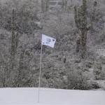 The pin flag on the 18th green blows in the falling snow during the Match Play Championship golf tournament, Wednesday, Feb. 20, 2013, in Marana, Ariz. Play was suspended for the rest of the day. (AP Photo/Julie Jacobson)