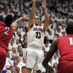 Arizona's Nick Johnson (13) shoots for two points between UNLV's Khem Birch (2) and Roscoe Smith (1) in the first half of an NCAA college basketball game on Saturday, Dec. 7, 2013, in Tucson, Ariz. Arizona won 63-58. (AP Photo/John MIller)
