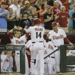 Arizona Diamondbacks' Martin Prado (14) is greeted by teammate Gerardo Parra, left, and manager Kirk Gibson after hitting a two-run home run against the Miami Marlins during the fourth inning of a baseball game, Tuesday, June 18, 2013, in Phoenix. (AP Photo/Matt York)
