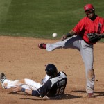 Los Angeles Angels shortstop Erick Aybar throws over Seattle Mariners' Alex Liddi (16) for the double play hit into by Brendan Ryan during an exhibition spring training baseball game, Monday, Feb. 25, 2013, in Peoria, Ariz. (AP Photo/Charlie Riedel)