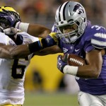  Kansas State's John Hubert, right, stiff-arms Michigan's Raymon Taylor (6) while running with the ball during the first half of the Buffalo Wild Wings Bowl NCAA college football game on Saturday, Dec. 28, 2013, in Tempe, Ariz. (AP Photo/Ross D. Franklin)