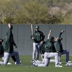 Oakland Athletics manager Bob Melvin, center, watches as players stretch before a spring training baseball workout Thursday, Feb. 14, 2013, in Phoenix. (AP Photo/Darron Cummings)