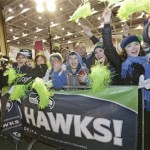 Fans greet Seattle Seahawks players and coaches during the team's arrival at Seattle-Tacoma International Airport, Monday, Feb. 3, 2014, in Seattle. The Seahawks defeated the Denver Broncos 43-8 in the Super Bowl on Sunday. (AP Photo/Elaine Thompson)