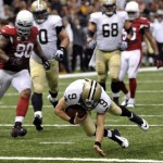 New Orleans Saints quarterback Drew Brees (9) dives over the goal line for a touchdown as Arizona Cardinals defensive end Darnell Dockett (90) watches in the second half of an NFL football game in New Orleans, Sunday, Sept. 22, 2013. (AP Photo/Bill Feig)