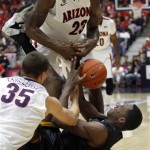 Arizona's Rodnae Hollis-Jefferson (23) and Kaleb Tarczewski (35) struggle with Long Beach State's Nick Shepherd, on floor, for control of a loose ball in the first half of an NCAA of an college basketball game, Monday, Nov. 11, 2013 in Tucson, Ariz. (AP Photo/John Miller) 