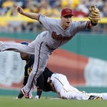 Arizona Diamondbacks second baseman Aaron Hill, top, reaches for the throw as Pittsburgh Pirates' Starling Marte steals second base in the first inning of a baseball game on Friday, Aug. 16, 2013, in Pittsburgh. (AP Photo/Keith Srakocic)