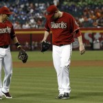 Arizona Diamondbacks' Martin Prado, left, comes in to check on pitcher Trevor Cahill who was struck by a line drive by Miami Marlins' Marcell Ozuna during the first inning of a baseball game on Wednesday, June 19, 2013, in Phoenix. (AP Photo/Ross D. Franklin)