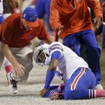 A trainer rushes to help Buffalo Bills quarterback EJ Manuel after he was injured on a third-quarter run against the Cleveland Browns in the third quarter of an NFL football game Thursday, Oct. 3, 2013, in Cleveland. (AP Photo/Tony Dejak)
