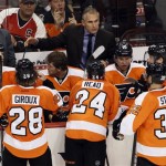 Philadelphia Flyers head coach Craig Berube, top center, gives directions to his players during a timeout in the third period of an NHL hockey game against the Phoenix Coyotes, Friday, Oct. 11, 2013, in Philadelphia. The Coyotes won 2-1. (AP Photo/Tom Mihalek)