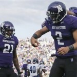 Northwestern quarterback Kain Colter (2) celebrates with running back Stephen Buckley (8) after scoring a touchdown as wide receiver Kyle Prater (21) looks on during the second half of an NCAA college football game against Maine in Evanston, Ill., Saturday, Sept. 21, 2013. Northwestern won 35-21. (AP Photo/Nam Y. Huh)