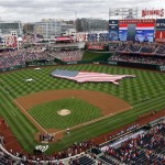 A U.S. flag, in the shape of the country, is unfurled in the outfield before a baseball game between the Washington Nationals and the Milwaukee Brewers at Nationals Park on Thursday, July 4, 2013, in Washington. (AP Photo/Mark Tenally)