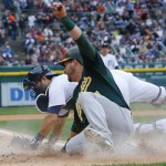 Oakland Athletics' Stephen Vogt safely beats the tag of Detroit Tigers catcher Alex Avila to scoree during the fourth inning of Game 3 of an American League baseball division series in Detroit, Monday, Oct. 7, 2013. (AP Photo/Paul Sancya)