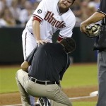 Arizona Diamondbacks pitcher Wade Miley grimaces as the team trainer looks at his leg after it was hit by a line drive by a Chicago Cubs batter during the third inning of a baseball game, Thursday, July 25, 2013, in Phoenix. (AP Photo/Matt York)