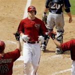 Arizona Diamondbacks' Paul Goldschmidt, middle, scores as teammates Willie Bloomquist (18) and Jason Kubel (13) wait at home plate during the fifth inning of a spring training baseball game against the Milwaukee Brewers on Wednesday, April 4, 2012, in Phoenix. (AP Photo/Ross D. Franklin)