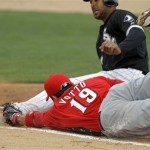 Cincinnati Reds first baseman Joey Votto (19) dives for the bag to double up Chicago White Sox's Alex Rios in the fourth inning of a spring training baseball game, Monday, March 19, 2012, in Glendale, Ariz. Rios was caught off the bag on a fly out by Paul Konerko in the Red's 1-0 win. (AP Photo/Mark Duncan)