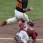 Arizona Diamondbacks catcher Miguel Montero, bottom, tags but drops the ball against San Francisco Giants' Tyler Colvin who scores off a single hit by Hector Sanchez during the fifth inning of a spring training baseball game on Sunday, March 2, 2014, in Scottsdale, Ariz. (AP Photo/Gregory Bull)