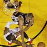 Miami Heat center Chris Bosh (1) and San Antonio Spurs power forward Tim Duncan (21) vie for a loose ball during the first half of Game 2 in the NBA Finals basketball game, Sunday, June 9, 2013 in Miami. (AP Photo/Mike Segar, Pool)