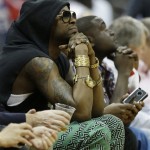 Singer Tauheed Epps, better known by his stage name 2 Chainz, left, watches play between the Atlanta Hawks and the Indiana Pacers during the first half in Game 4 of their first-round NBA basketball playoff series game, Monday, April 29, 2013 in Atlanta. (AP Photo/John Bazemore)