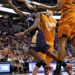  New Orleans Pelicans' Tyreke Evans (1) drives past Phoenix Suns' Miles Plumlee, rear, during the first half of an NBA basketball game, Friday, Feb. 28, 2014, in Phoenix. (AP Photo/Matt York)