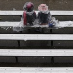 Spectators wait for a race in the rain before the 139th Kentucky Derby at Churchill Downs Saturday, May 4, 2013, in Louisville, Ky. (AP Photo/David Goldman)
