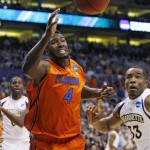 Florida's Patric Young (4) chases a loose ball as Marquette's Jamil Wilson, left, and Derrick Wilson look on during the first half of an NCAA men's college basketball tournament West Regional semifinal on Thursday, March 22, 2012, in Phoenix. (AP Photo/Matt York)