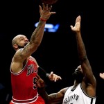 Chicago Bulls forward Carlos Boozer, left, shoots against Brooklyn Nets' Reggie Evans during the second half in Game 7 of their first-round NBA basketball playoff series in New York, Saturday, May 4, 2013. (AP Photo/Julio Cortez)