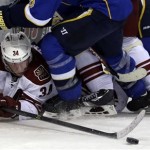 Phoenix Coyotes' Tim Kennedy passes the puck after falling to the ice during the third period of an NHL hockey game against the St. Louis Blues on Tuesday, Jan. 14, 2014, in St. Louis. The Blues won 2-1. (AP Photo/Jeff Roberson)