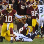 Washington Redskins quarterback Robert Griffin III reacts to a touchdown by running back Evan Royster, background, during the first half of an NFL wild card playoff football game against the Seattle Seahawks in Landover, Md., Sunday, Jan. 6, 2013. (AP Photo/Richard Lipski)
