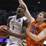 Marquette's Darius Johnson-Odom, left, looks for a shot against Florida's Erik Murphy during the first half of an NCAA men's college basketball tournament West Regional semifinal on Thursday, March 22, 2012, in Phoenix. (AP Photo/Chris Carlson)