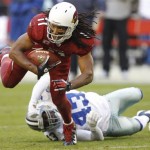 Arizona Cardinals wide receiver Larry Fitzgerald (11) escapes the reach of Dallas Cowboys free safety Gerald Sensabaugh (43) during the second half of an NFL football game, Sunday, Dec. 4, 2011, in Glendale, Ariz. (AP Photo/Paul Connors)