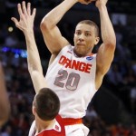 Syracuse guard Brandon Triche (20) passes over Wisconsin guard Josh Gasser (21) in the second half of an East Regional semifinal game in the NCAA men's college basketball tournament, Thursday, March 22, 2012, in Boston. Syracuse won 64-63. (AP Photo/Michael Dwyer)