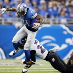 Baltimore Ravens cornerback Jimmy Smith (22) tackles Detroit Lions wide receiver Calvin Johnson (81) during the third quarter of an NFL football game in Detroit, Monday, Dec. 16, 2013. (AP Photo/Paul Sancya)