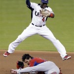 Puerto Rico's Angel Pagan steals second base as United States second baseman Brandon Phillips leaps over him during the first inning of a second-round World Baseball Classic game, Tuesday, March 12, 2013, in Miami. (AP Photo/Wilfredo Lee)