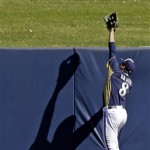Milwaukee Brewers' Ryan Braun climbs a wall to try and make a catch during a spring training baseball workout, Friday, Feb. 22, 2013, in Phoenix. (AP Photo/Morry Gash)