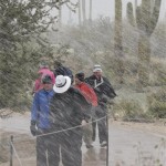 Spectators make their way off the course in driving rain and snow during the Match Play Championship golf tournament, Wednesday, Feb. 20, 2013, in Marana, Ariz. Play was suspended for the day. (AP Photo/Ted S. Warren)