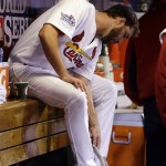 St. Louis Cardinals starting pitcher Adam Wainwright cleans his cleats in the dugout during the third inning of Game 5 of baseball's World Series against the Boston Red Sox Monday, Oct. 28, 2013, in St. Louis. (AP Photo/Jeff Roberson)