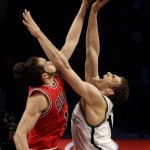 Chicago Bulls center Joakim Noah, left, blocks Brooklyn Nets center Brook Lopez during the second half in Game 7 of their first-round NBA basketball playoff series in New York, Saturday, May 4, 2013. (AP Photo/Julio Cortez)